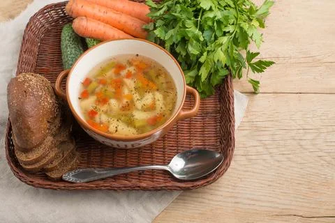 Vegetable soup surrounded by fresh vegetables. Stock Photos