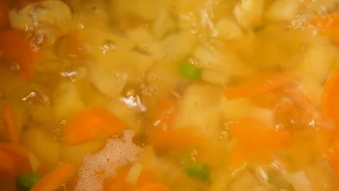 Vegetable soup. Vegetables in boiling water. Potatoes, carrots, onions, peas Stock Footage 121853767
