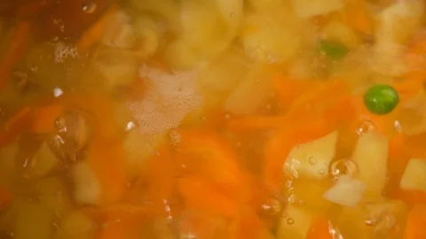 Vegetable soup. Vegetables in boiling water. Potatoes, carrots, onions, peas Stock Footage 121853817
