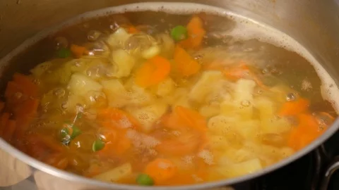 Vegetable soup. Vegetables in boiling water. Potatoes, carrots, onions, peas Stock Footage 121853888