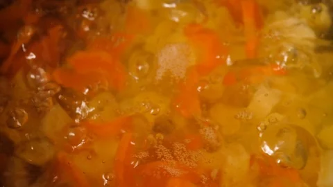 Vegetable soup. Vegetables in boiling water. Potatoes, carrots, onions, peas Stock Footage 129695123