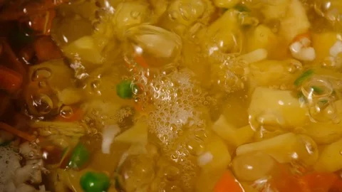 Vegetable soup. Vegetables in boiling water. Potatoes, carrots, onions, peas Stock Footage 129695265