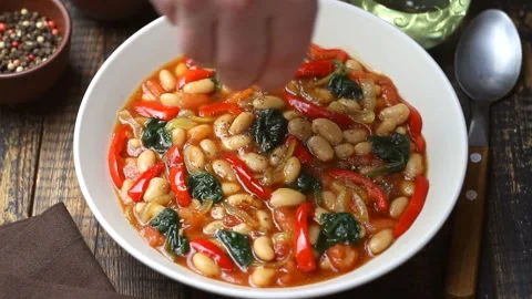 Vegetable stew with beans, spinach, peppers, tomatoes, and onions. Vídeo Stock 325802049