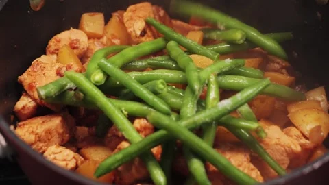 Vegetable stew with chicken is stewed in a saucepan with aromatic spices and Stock Footage 316901950