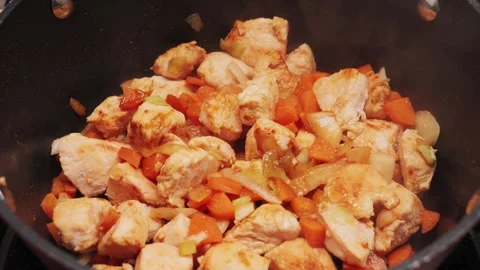 Vegetable stew with chicken is stewed in a saucepan with aromatic spices and Stock Footage 316901964