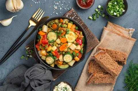 Vegetable stew, rye bread and greens on a gray-blue background. Foto stock
