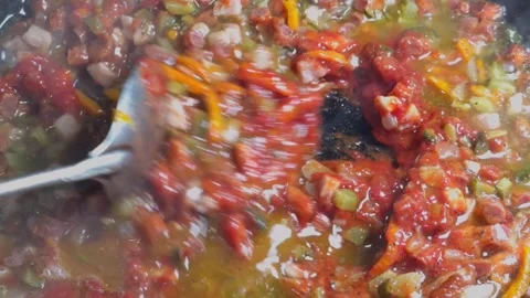 Vegetable stew with tomatoes and spices is simmering in a pan, stirred with.. Video stock 323225565
