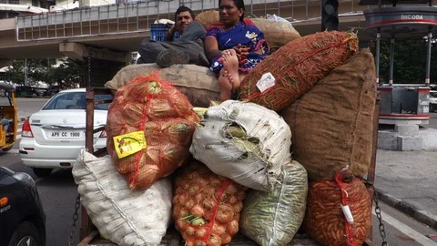 Vegetable-vendors-sitting-on-bag-of-vegetables-behind-pickup-truck Stock Footage 94049573