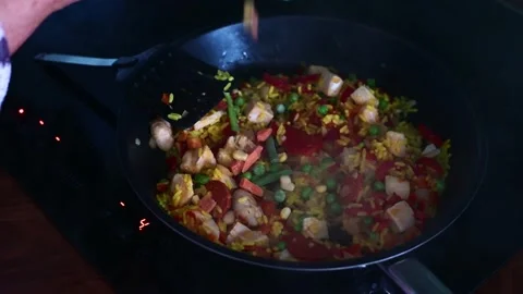 Vegetables added to chicken chorizo while cooking in frying pan on hob at home Video stock 137817716