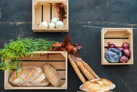 Vegetables and bread in wooden boxes. Stock Photos