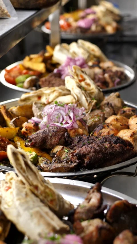 Vegetables and grilled meat on a plate sprinkled with herbs before serving Stock Footage 306750583