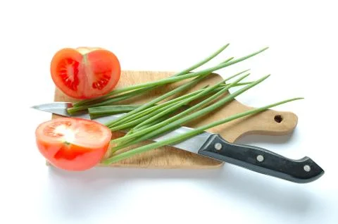 Vegetables and knife on chopping board on white background Stock Photos