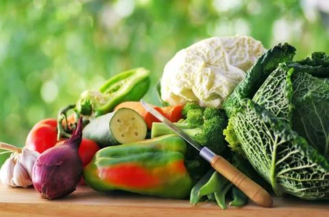 Vegetables and knife on table Stock Photos