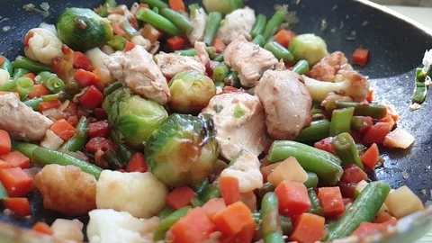 Vegetables and meat are fried in a pan Stock Footage 105950733