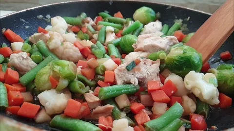 Vegetables and meat are fried in a pan Video stock 105950823