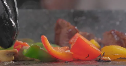 Vegetables and meat cooked in a frying pan. Chef prepares steaming colorful Stock Footage 252381341