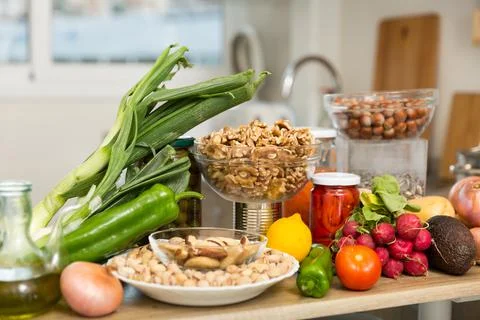 Vegetables and nuts on kitchen table Photos