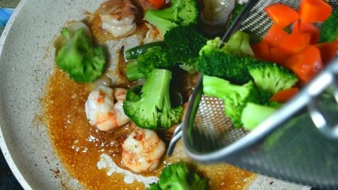 Vegetables are being sprinkled on top of the shrimp Stock Footage 137029338