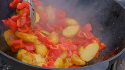 Vegetables are fried in a cauldron. Bright vegetables are fried in a cauldron Stock Footage 284940521
