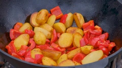 Vegetables are fried in a cauldron. Bright vegetables are fried in a cauldron Stock Footage 307313755