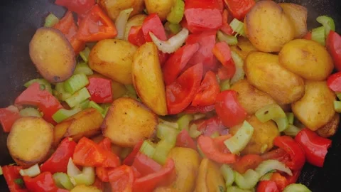 Vegetables are fried in a cauldron over a fire. Stewing vegetables on the fire Stock-Footage 278464971