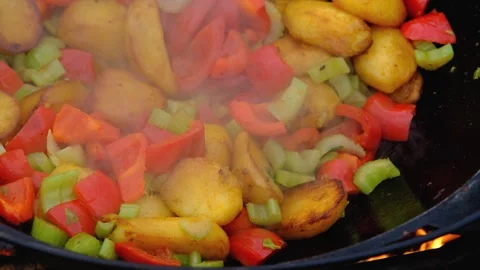 Vegetables are fried in a cauldron over a fire. Stewing vegetables on the fire Stock Footage 278868871