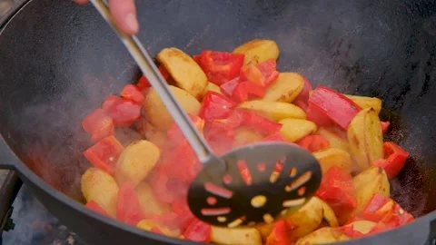 Vegetables are fried in a cauldron over a fire. Stewing vegetables on the fire Stock Footage 280354793
