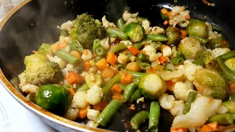 Vegetables are fried in a frying pan Stock Footage