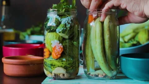 Vegetables are put in jars for pickling Stock Footage 249813938
