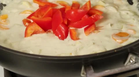 Vegetables being added to a coconut curry sauce Stock-Footage 24672670