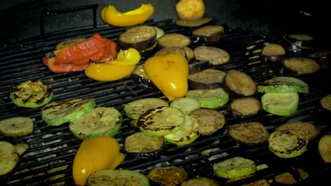 Vegetables being cooked on a hot grill. Zucchini, paprika and eggplant Stock Footage 157536763