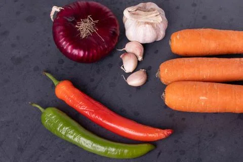 Vegetables on black stone surface Stock Photos