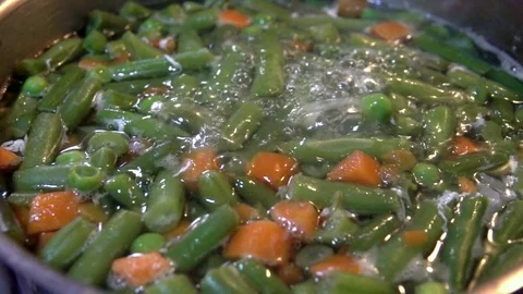 Vegetables boiling in a pot, chopped into cubes, diced, slow motion. Video stock 77621699