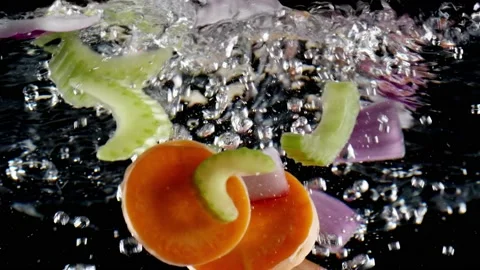 Vegetables boiling in water on black background Vidéo 130876889
