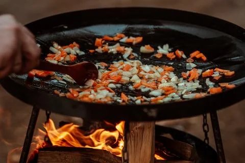 Vegetables cooked on a grill pan over an open fire in the woods. Cooking Stock Photos