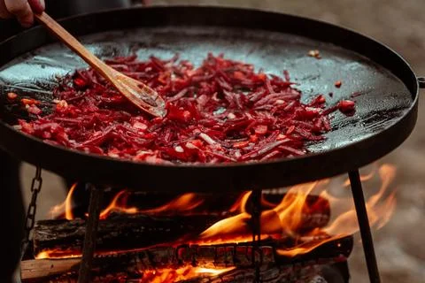 Vegetables cooked on a grill pan over an open fire in the woods. Cooking Stock Photos