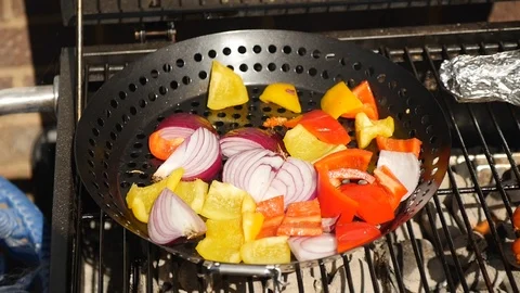 Vegetables cooking in a pan on a BBQ Stock Footage 115058714