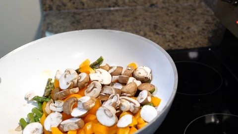 Vegetables cooking in a white frying pan Stock Footage 110458317