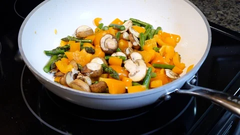 Vegetables cooking in a white frying pan Stock Footage 110460010
