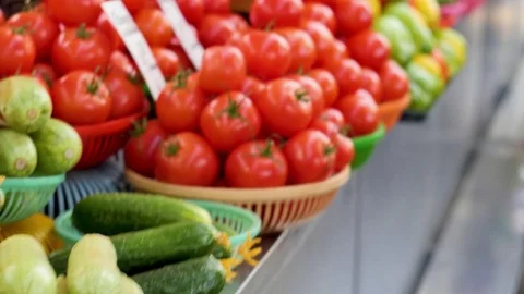 Vegetables, cucumbers, tomatoes, pepper lie on the counter. A girl chooses Stock Footage 82916211