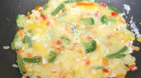 Vegetables drenched egg stirred in a pan Stock Footage 49603522