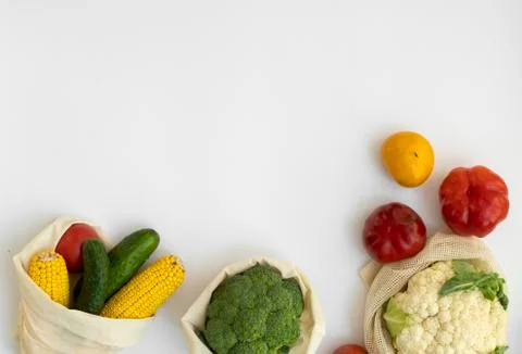 Vegetables in eco bag on white surface with a copy space. Pepper, tomato, corn Stock Photos