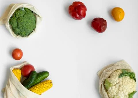 Vegetables in eco bag on white surface with a copy space. Pepper, tomato, corn Stock Photos