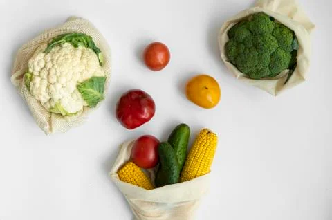 Vegetables in eco bag on white surface. Pepper, tomato, corn, cucumber, broccoli Stock Photos