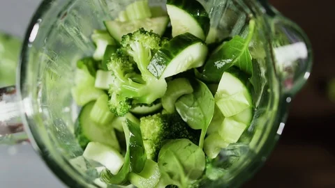 Vegetables fall in blender, slow motion. Green smoothie in blender, top view. 動画素材 124405834