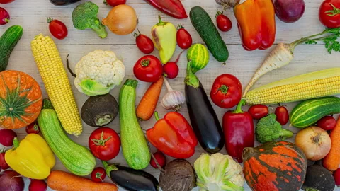 Vegetables fall on white wooden background, stop motion animation, 4K Stock Footage 141425366