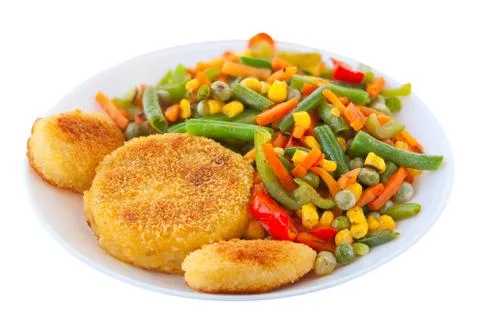 Vegetables gorse or tomatoes corn peas bell peppers carrots on plate Stock Photos
