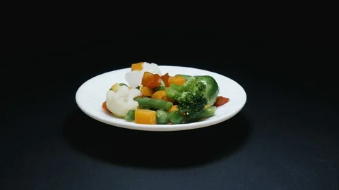 Vegetables jump into the white plate (stop motion) Stock Footage 101072921