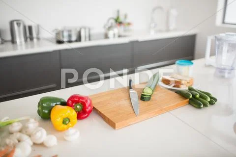 Vegetables with knife and chopping board on kitchen counter Stock-Fotos