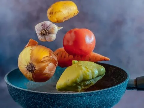 Vegetables levitating over a frying pan for a vegetable stew. Cooking concept Stock Photos